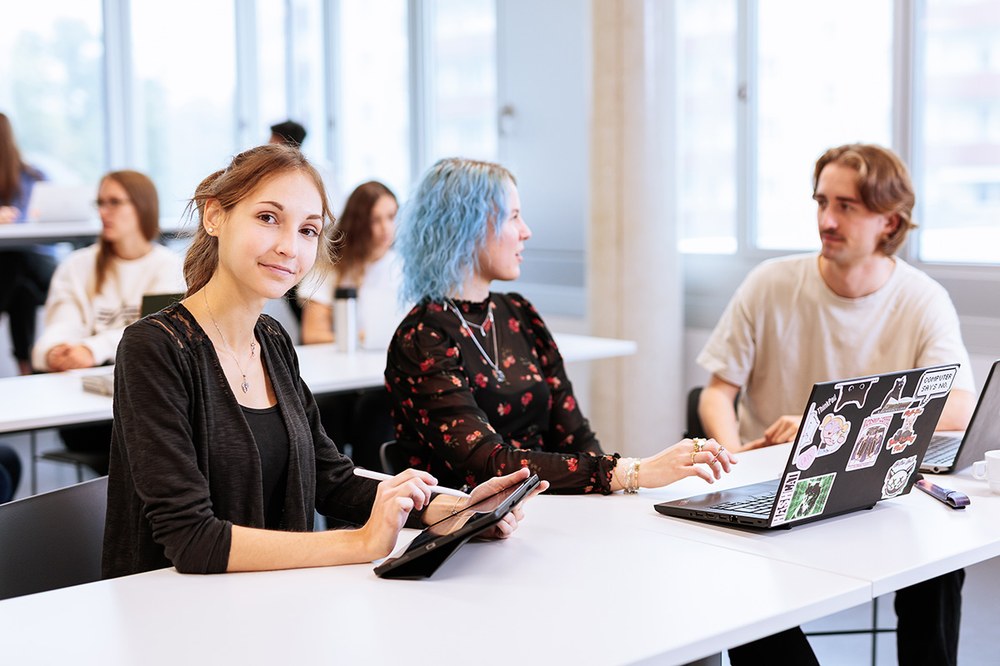 Studierende am Laptop und Tablet