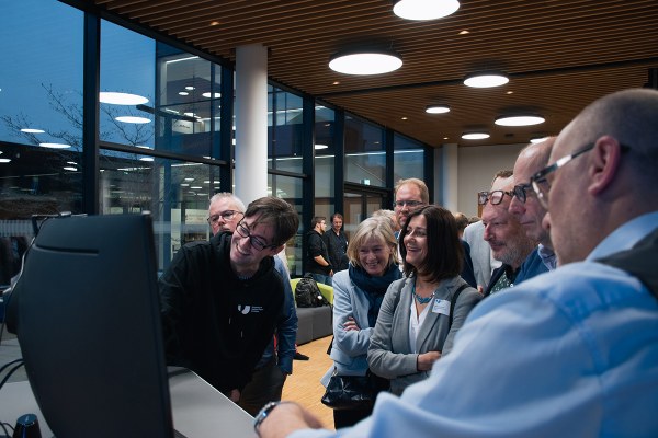 A group watches the project with interest.