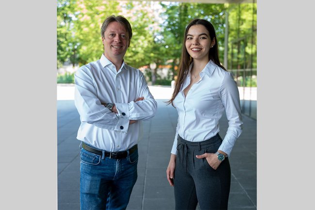 Links im Bild: Alexander Adrowitzer, Rechts: Laura Kaltenbrunner - beide stehen vor dem Hauptgebäude der FH, im Hintergrund sind Bäume sichtbar
