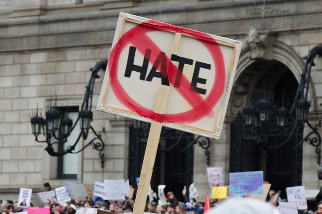 A sign reading "HATE" with a red circle and a slash through it.
