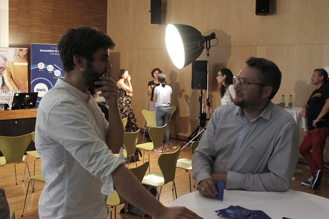 Research Café: Mehrere Gruppen von Personen im Gespräch im kleinen Festsaal an der FH St. Pölten