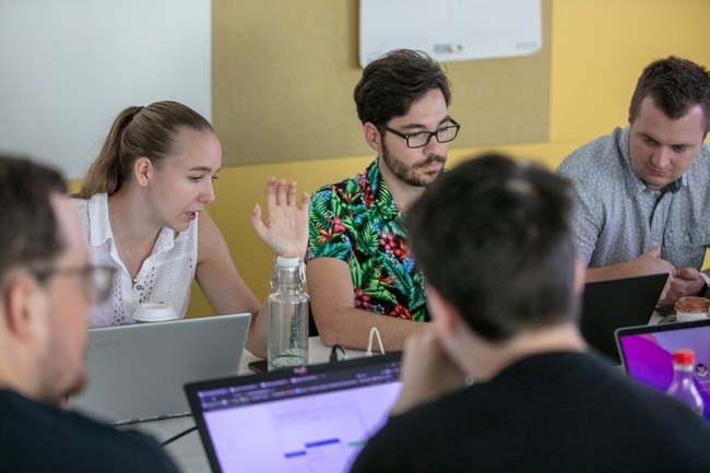 Studierende mitten im Cyber-Planspiel – sie sitzen mit ihren Laptops an einem Tisch