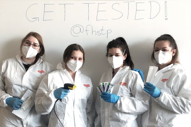 Vier Studentinnen in Schutzkleidung mit allem Zubehör, was sie für eine Testung brauchen