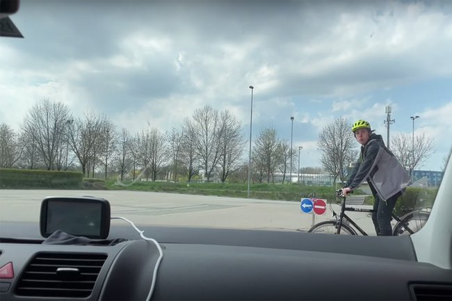 Filmausschnitt von "Prävention, Oida!": Die Perspektive ist innerhalb eines Autos, das sich auf einen Fahrradfahrer zubegewegt