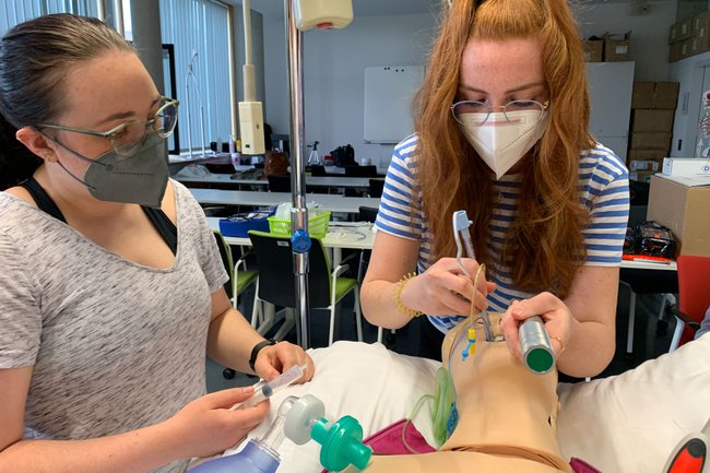 2 Studentinnen üben an einer Puppe die cardiopulmonale Reanimation